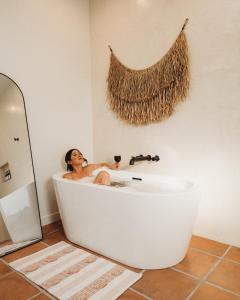 a woman sitting in a bath tub with a glass of wine at Bolder House By The Cohost Company in Joshua Tree +90 photos
