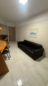 a living room with a black couch and a table at MANHATTAN - JK APART Hotel in Brasilia