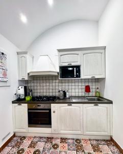 a kitchen with white cabinets and a stove top oven at Casa Ginevra, Private Garage, Vaulted Ceilings in Lecce +11 photos