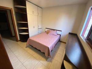 una camera con un letto e una coperta rosa di Apartamento quadra mar a Meia Praia