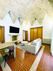een woonkamer met een bank en een tv bij Casa Ginevra, private Parking in Lecce