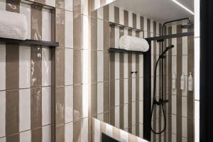 a bathroom with a shower with striped walls at Four Points Flex by Sheraton London Euston in London +18 photos