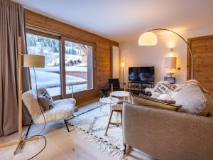 un soggiorno con divano, sedie e finestra di Chalet Méribel 6 pers., jacuzzi, ski-in/ski-out - FR-1-355-211 a Les Allues