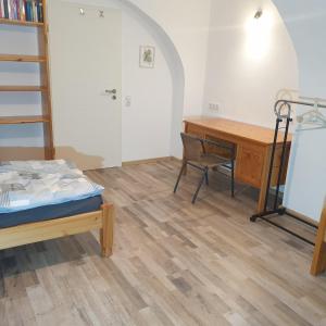 a bedroom with a desk and a bed and a desk and chair at FeWo PAN in Pfarrkirchen +4 photos