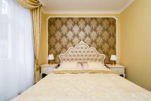 a bedroom with a large bed with a white headboard at Hotel Saint Petersburg in Karlovy Vary