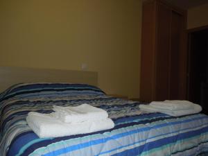 dos toallas sentadas encima de una cama en Apartamento Cuatro Torres, en Madrid