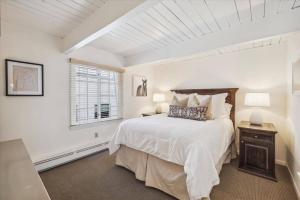 una camera da letto bianca con un letto e una finestra di 2 Bedroom Condo In Downtown Aspen, Just One Block To Silver Queen Gondola ad Aspen