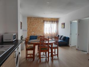 a kitchen and living room with a table and chairs at Las Casas Rurales de Los Olivos in Tabernas