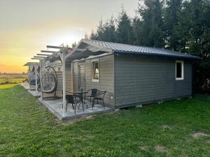 a small cabin with a table and chairs on a deck at U Joanny in Kopań