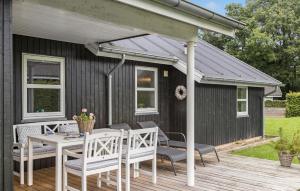 a patio with a table and chairs on a deck at Holiday Home Barsbæklund Aabenraa in Loddenhøj