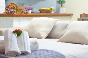 a white bed with white pillows and a flower on it at Entire apartment in villa with parking in Frascati +8 photos
