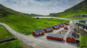 eine Reihe roter Häuser auf einer grünen Wiese in der Unterkunft Discover This Well-appointed Cottage Cottage D in Vágur + 10 Fotos