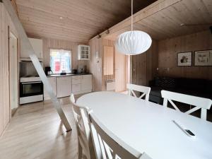 eine Küche und ein Esszimmer mit einem weißen Tisch und Stühlen in der Unterkunft Discover This Well-appointed Cottage Cottage D in Vágur