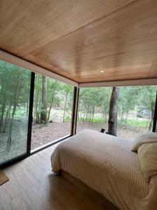 En eller flere senge i et værelse på Tiny house en pleno bosque a metros de la laguna