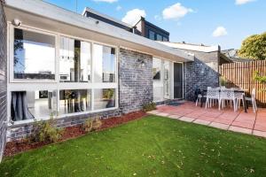 a brick house with a patio and grass at Belmont 3BR Townhome by Short and Long Stays in Belmont