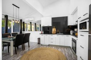 a kitchen with white cabinets and a table with chairs at Belmont 3BR Townhome by Short and Long Stays in Belmont