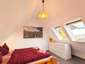 a attic bedroom with a bed and two windows at Urlaubsmagie - Ferienwohnung Biberburg - mit Balkon - B7 in Lichtenhain