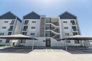 an apartment building with two umbrellas in front of it at Casa Bella in Summerstrand