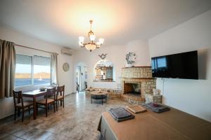 a living room with a table and a fireplace at Gialiskari Studios in Gialiskari