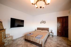 a bedroom with a bed and a flat screen tv at Gialiskari Studios in Gialiskari