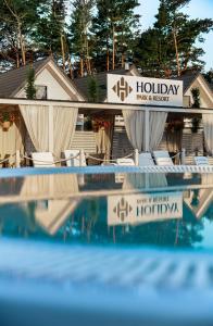 a view of a hotel with chairs and a swimming pool at Holiday Park & Resort Niechorze Rewal in Niechorze