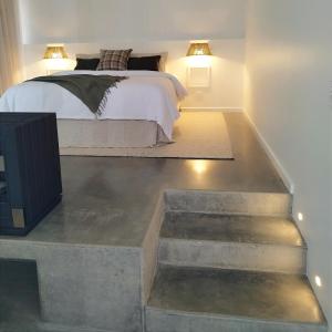 a bedroom with a bed and a concrete floor at Edge Luxury Villas in Wilyabrup