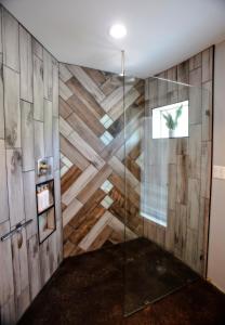ducha en una habitación con pared de madera en The Barn Silo At Goose Lake Lane, en Glendale 30 fotos más