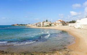 a sandy beach with houses and the ocean at Lovely Home In Punta Braccetto in Punta Braccetto +24 photos