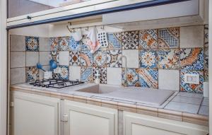 a kitchen with a sink and tiles on the wall at Lovely Home In Punta Braccetto in Punta Braccetto