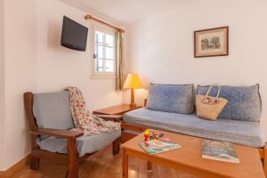 a living room with a couch and a chair at Résidence Partenaire Le domaine de Garlande in Cavalaire-sur-Mer