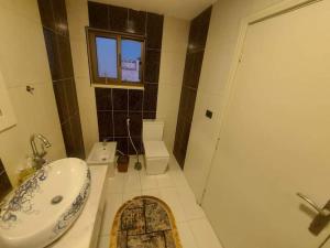 Un baño con lavabo, inodoro y ducha. en The view IVI, en Umm Uthainah
