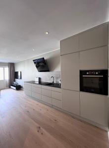 オスロにあるFrogner - Newly renovated apartment - 3 bedroomsの白いキャビネットとシンクのあるキッチン