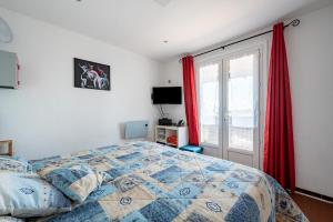 a bedroom with a bed and a window with red curtains at Le Tau - Appt proche plage pour 5 in Saintes-Maries-de-la-Mer +3 photos