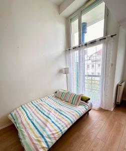 a bed in a room with a large window at Jade Apart Bussy Centre Disney 10min in Bussy-Saint-Georges