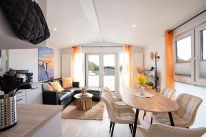a kitchen and living room with a table and chairs at Ostseecamp Ferienhaus "Pier 99" in Scharbeutz