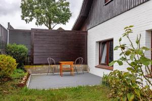 a wooden table and two chairs on a patio at Gemütliche Wohnung Buchholz i d N in Buchholz in der Nordheide