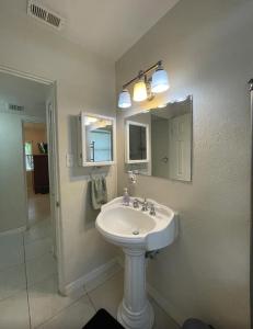 Un baño blanco con lavabo y espejo. en Centrally Located Pet-friendly peaceful home, en San Petersburgo