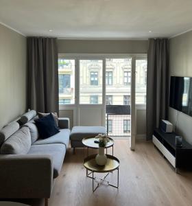 オスロにあるFrogner - Newly renovated apartment - 3 bedroomsのソファとテレビのあるリビングルーム