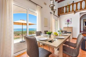 a dining room with a table and a view of the ocean at Villa Proa by Villa Plus in Alaior