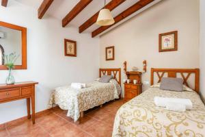 a bedroom with two beds and a table at Villa Proa by Villa Plus in Alaior