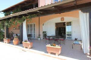 an outdoor patio with a table and chairs and plants at Appartamento Villa Poggio La Leona in Cerbaia