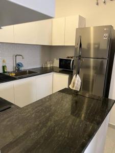 a kitchen with a stainless steel refrigerator and white cabinets at Luxury apartment The Flemington - 20 Vajira Rd in Colombo