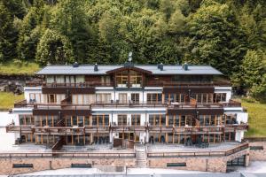 duży drewniany budynek z mnóstwem okien w obiekcie Gerlos Alpine Estate - Gerlos w mieście Gerlos