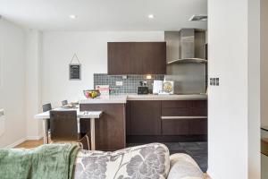 a kitchen with brown cabinets and a table in a room at Pass the Keys Central Altrincham 2Bed Apartment in Altrincham