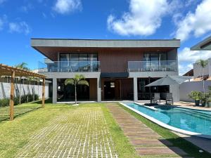 an exterior view of a house with a swimming pool at Grand Lux House Barra São Miguel Hosti Hospedagens in Barra de São Miguel