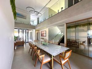 a dining room with a large table and chairs at Grand Lux House Barra São Miguel Hosti Hospedagens in Barra de São Miguel