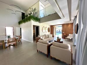 a large living room with couches and a dining room at Grand Lux House Barra São Miguel Hosti Hospedagens in Barra de São Miguel
