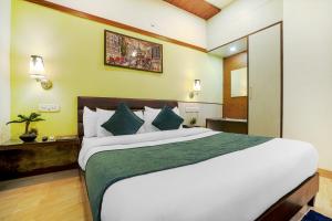 a bedroom with a large white bed with blue pillows at Hotel7 in Chandīgarh