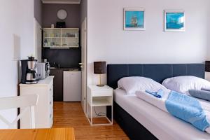 a bed with a blue headboard in a room at CBlue "Apartmenthaus Padua", zentral in Warnemünde