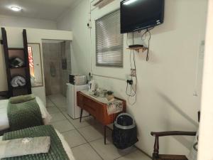 a living room with a couch and a television on a wall at De Anker Verblyf in Olifantshoek